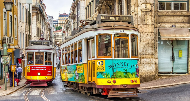 A photo of two yellow trams in Lisbon, Portugal